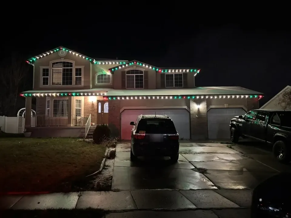 Two-story home in a red, green and white pattern on both rooflines
